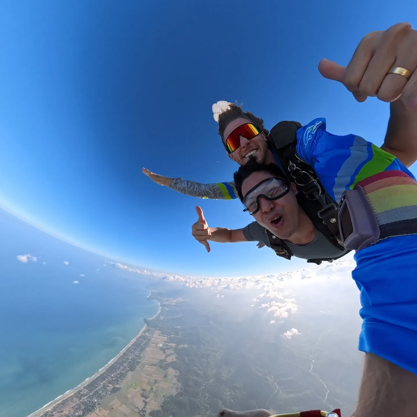 Handcam-selfie af et tandempar i frit fald over kysten ved San Vicente